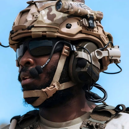 Lifestyle shot of Coyote Brown (CB) Level IIIA ACH high-cut ballistic helmet with MC camouflage cover, mounted tactical light, comms headset, and hook-and-loop patches, worn by a tactical operator