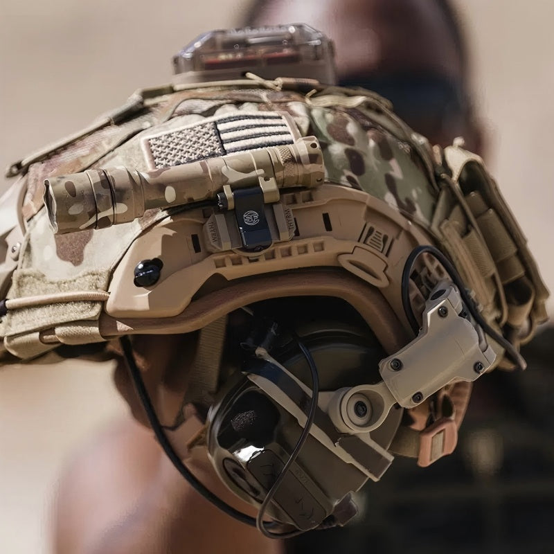 Tactical use display of Coyote Brown (CB) Level IIIA ACH high-cut ballistic helmet with MC camouflage cover, mounted accessories, comms headset, and hook-and-loop patches